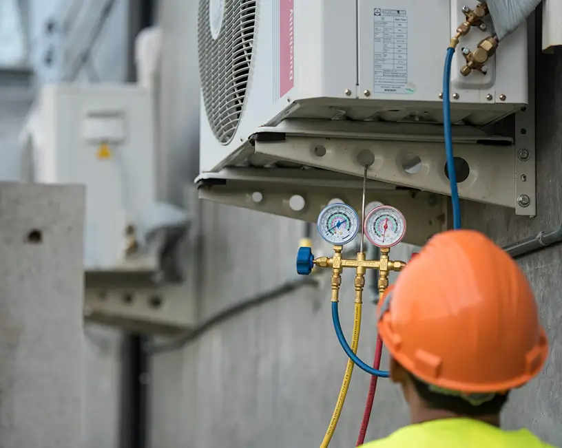 B and Z Heating & Air Conditioning HVAC technician using manifold gauges to service refrigerant levels